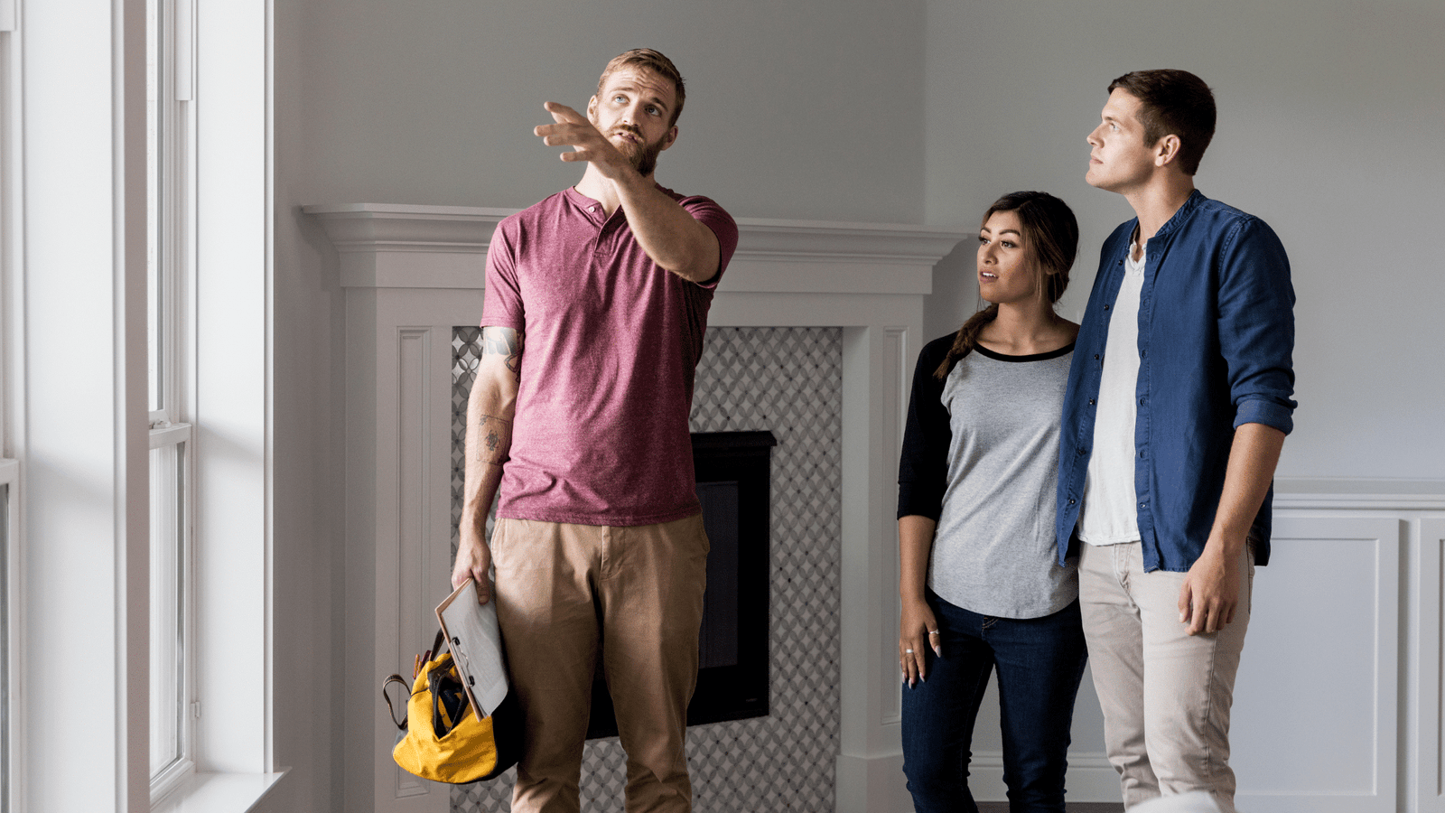 Professional handyman consulting with homeowners about home improvement or repair services in a modern living room.