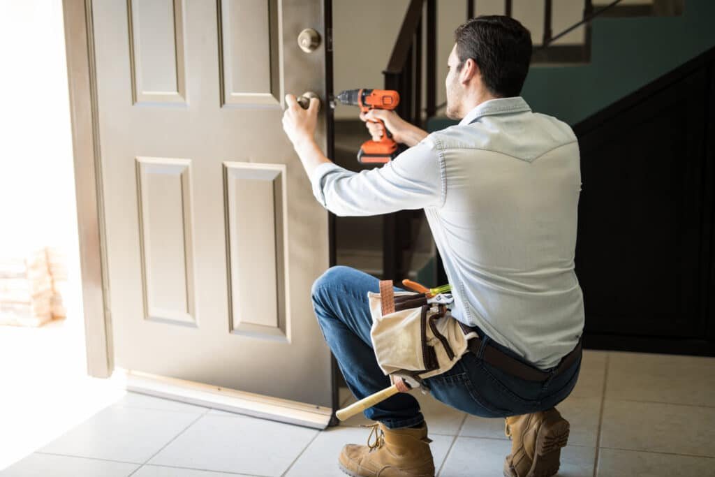 Handy Hive Pros technician installing a new door lock, ensuring secure and professional lock replacement services for homeowners in Tampa, FL.