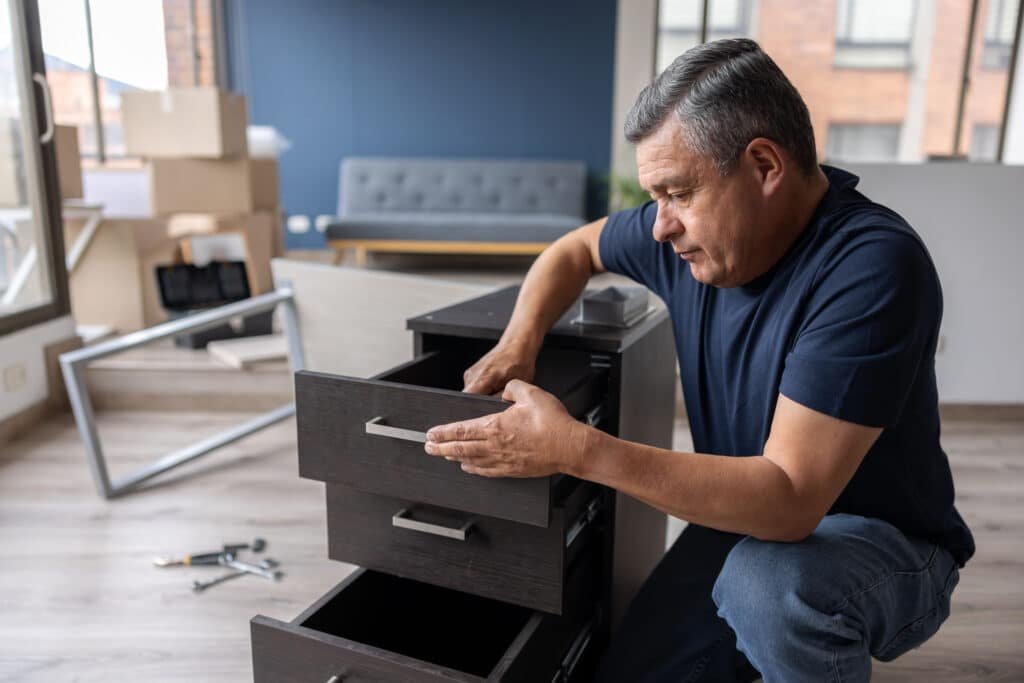 Handy Hive Pros technician assembling a drawer unit in a modern apartment, providing professional furniture assembly services.