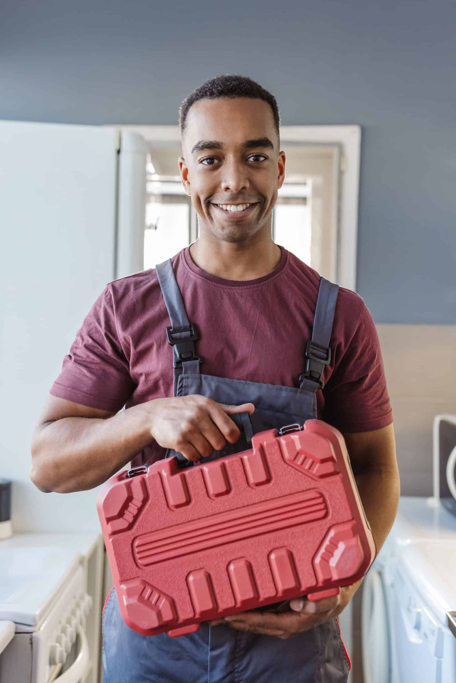 Handy Hive Pros handyman in work uniform holding a red toolbox, ready for professional home repair and maintenance services.